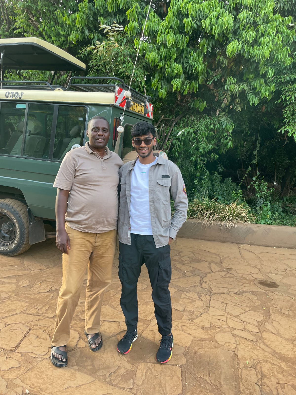 David standing with a guest beside his safari vehicle